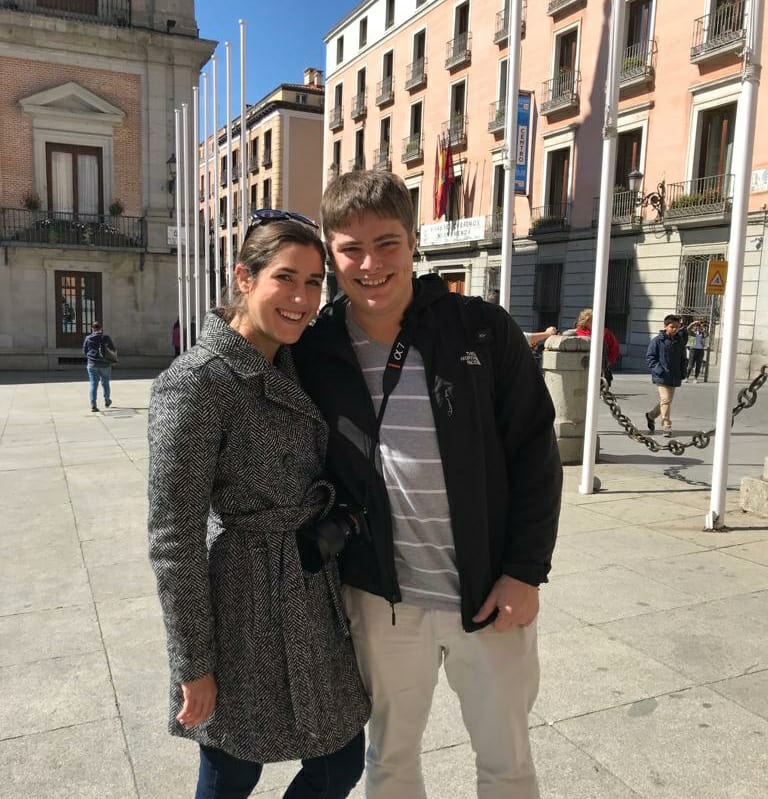 凯特·斯道姆和杰里米·斯道姆站在西班牙马德里的一个广场上，身后是一座粉红色的建筑