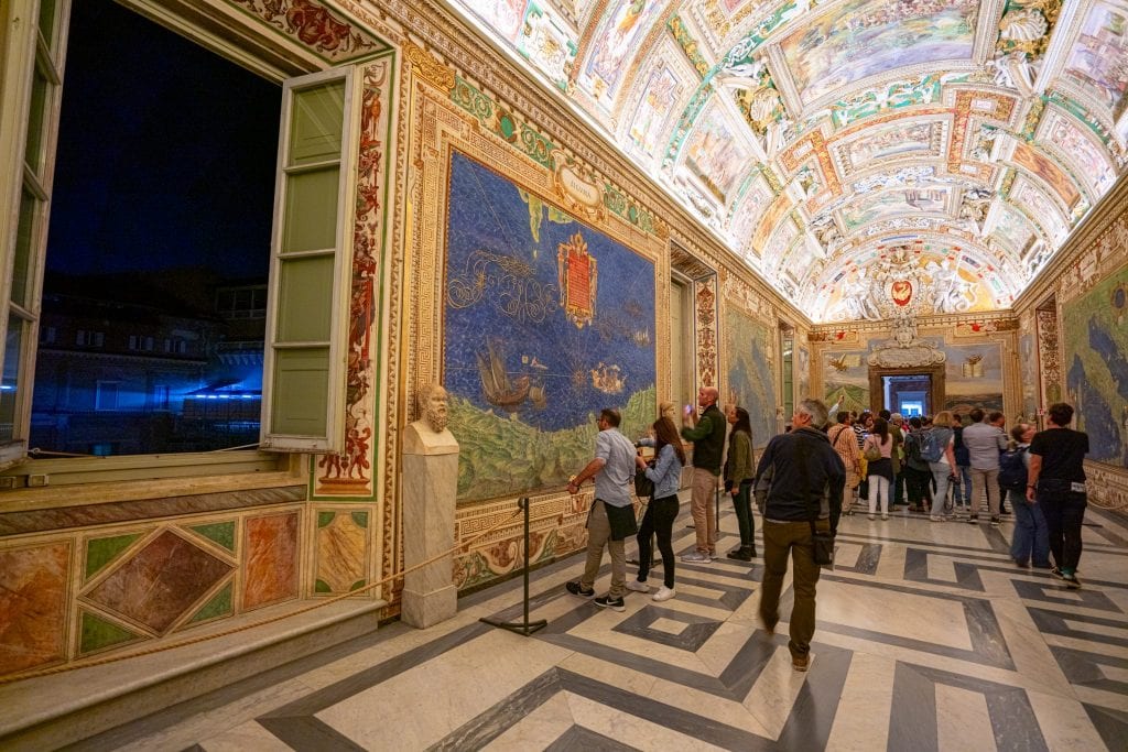 梵蒂冈博物馆的地图室在晚上拍摄，左边开着窗户。在特殊时间参观梵蒂冈博物馆是我们最喜欢的意大利罗马旅游贴士之一!必威体育官方登录