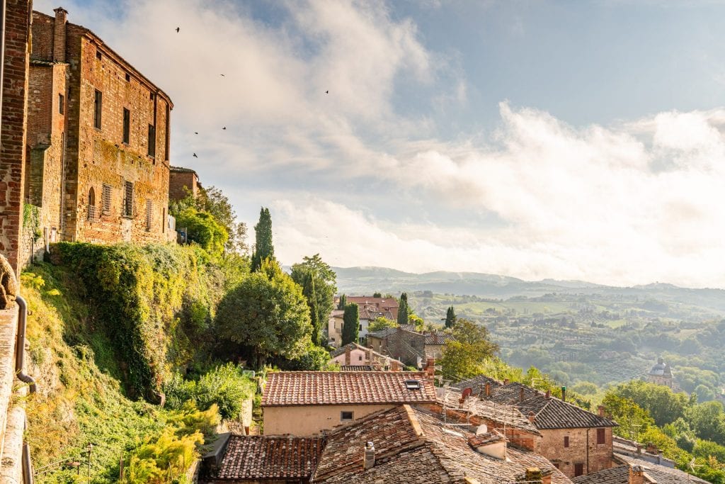 从蒙特普尔恰诺俯瞰托斯卡纳乡村的景色，左边是村庄，从罗马开车到佛罗伦萨的公路旅行的最佳站点之一
