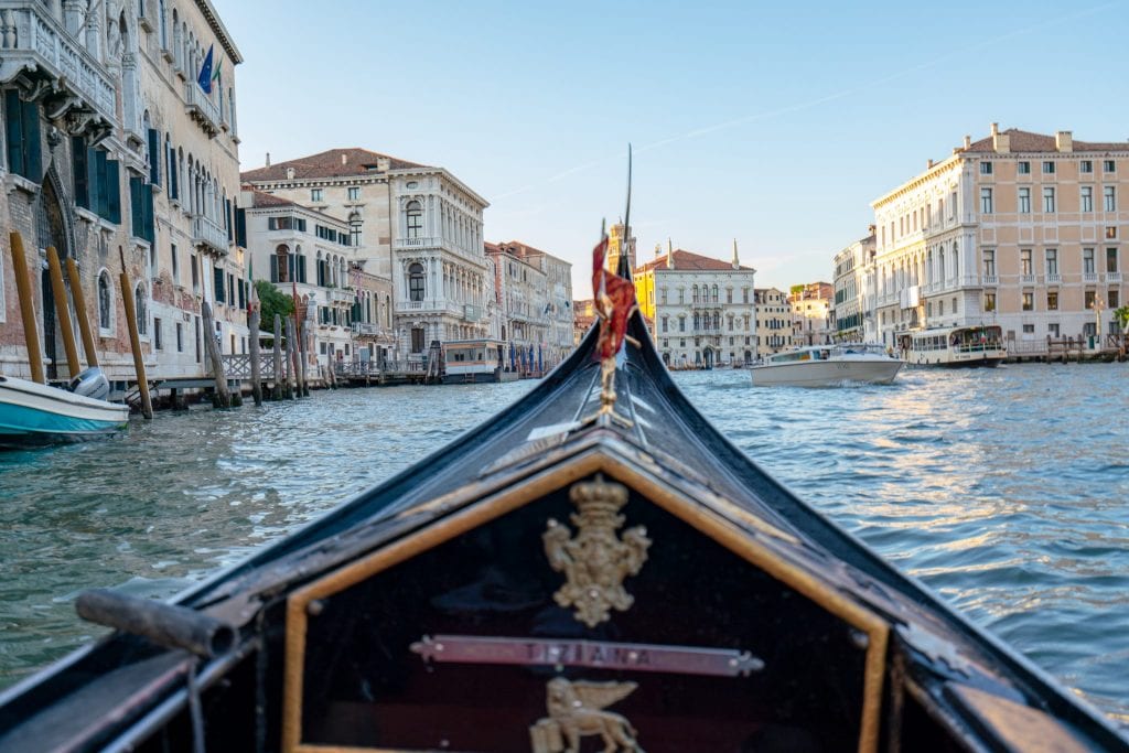 前面的贡多拉以大运河为背景拍摄——贡多拉之旅是你从佛罗伦萨到威尼斯一日游的绝佳补充!