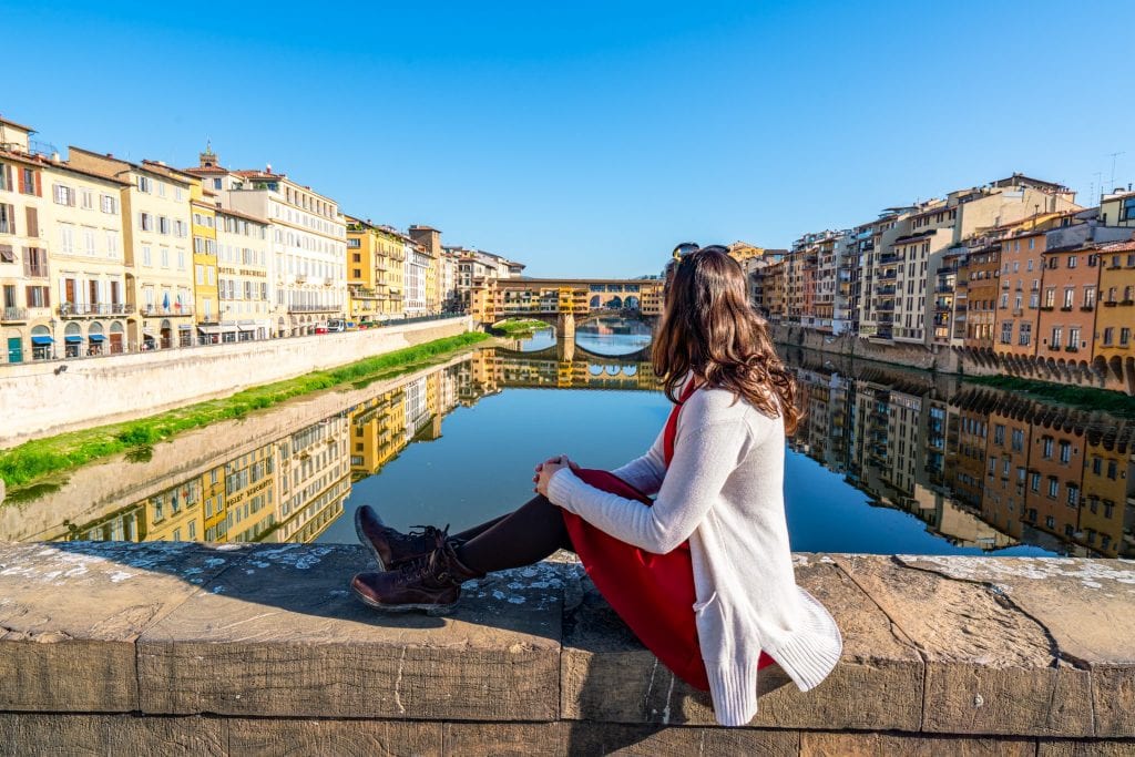 身着红裙的凯特·斯道姆在意大利佛罗伦萨俯瞰维奇奥桥