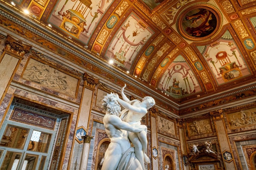 Interior of the Galleria Borghese in Rome, with a baroque statue in the center of the frame