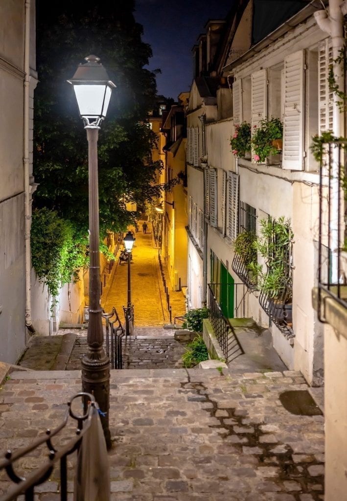 在巴黎蒙马特大街的夜晚，左边有一盏路灯。蒙马特区是在巴黎度过一个夜晚的好地方