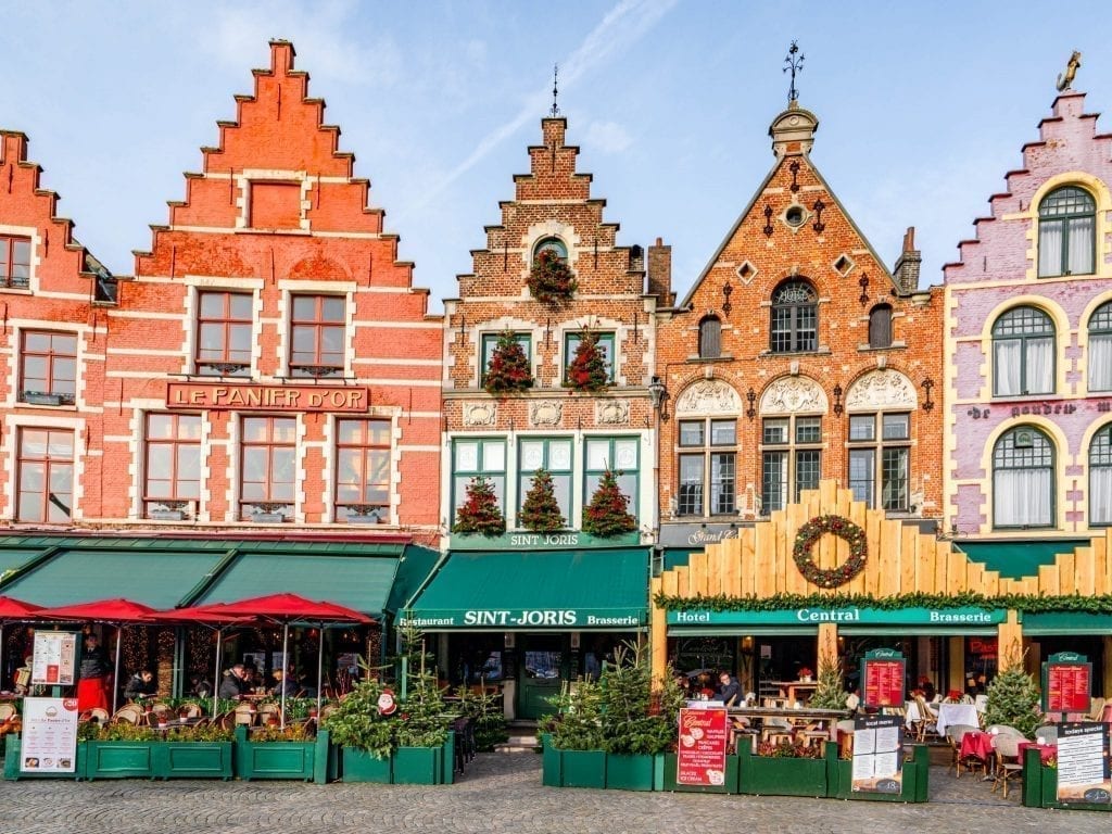 比利时布鲁日的Grote Markt有4座彩色的建筑，前面有绿色的遮阳篷，这是您在比利时3天行程中必不可少的一站