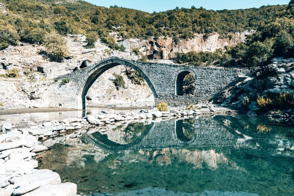 在阿尔巴尼亚人的自驾游中，在亮蓝色的河流上建造了一座石桥
