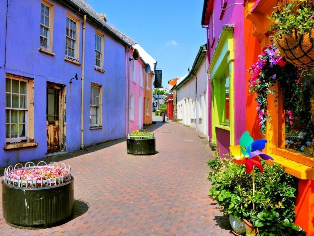 色彩鲜艳的街道在金塞尔爱尔兰与一个紫色的建筑在左边前景和一个红色的建筑在右边前景。金塞尔是爱尔兰最漂亮的小镇之一。