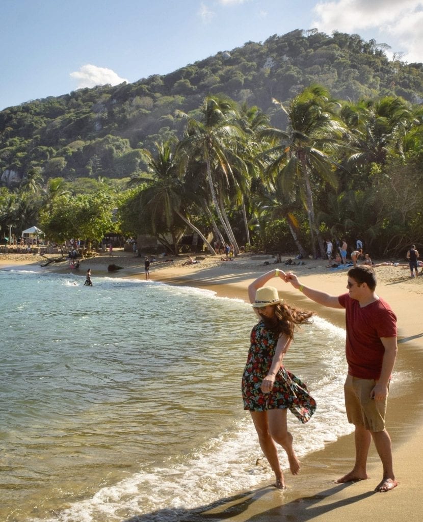 凯特·斯道姆和杰里米·斯道姆在哥伦比亚泰罗纳国家公园的海滩上一起旋转。一定要带墨镜和裙子