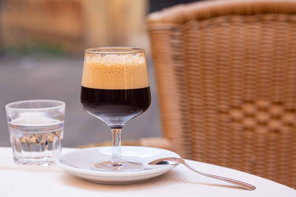 一杯咖啡放在意大利咖啡桌上，旁边放着一杯水