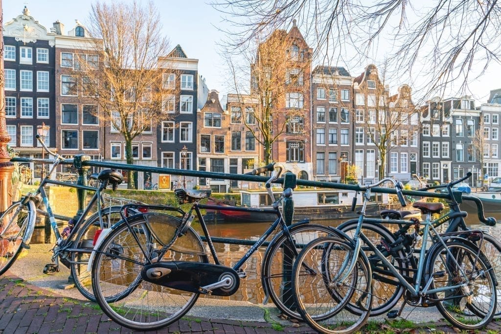 阿姆斯特丹的运河景观，前景是停放的自行车——作为阿姆斯特丹一日游行程的一部分，您将体验到许多这样的风景
