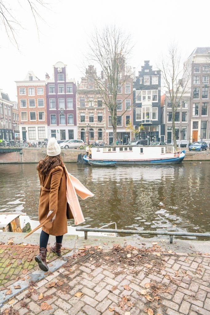 12月，身着棕色外套的凯特·斯道姆俯瞰雾蒙蒙的阿姆斯特丹运河
