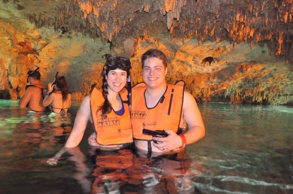 凯特·斯道姆和杰里米·斯道姆在墨西哥里维拉玛雅的一个封闭天然井里，穿着橙色救生衣
