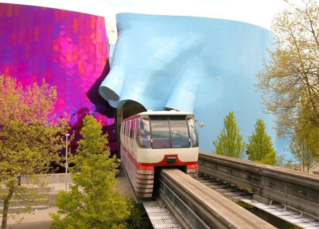西雅图单轨铁路离开了一个彩色的隧道，隧道的一边是紫色，另一边是蓝色