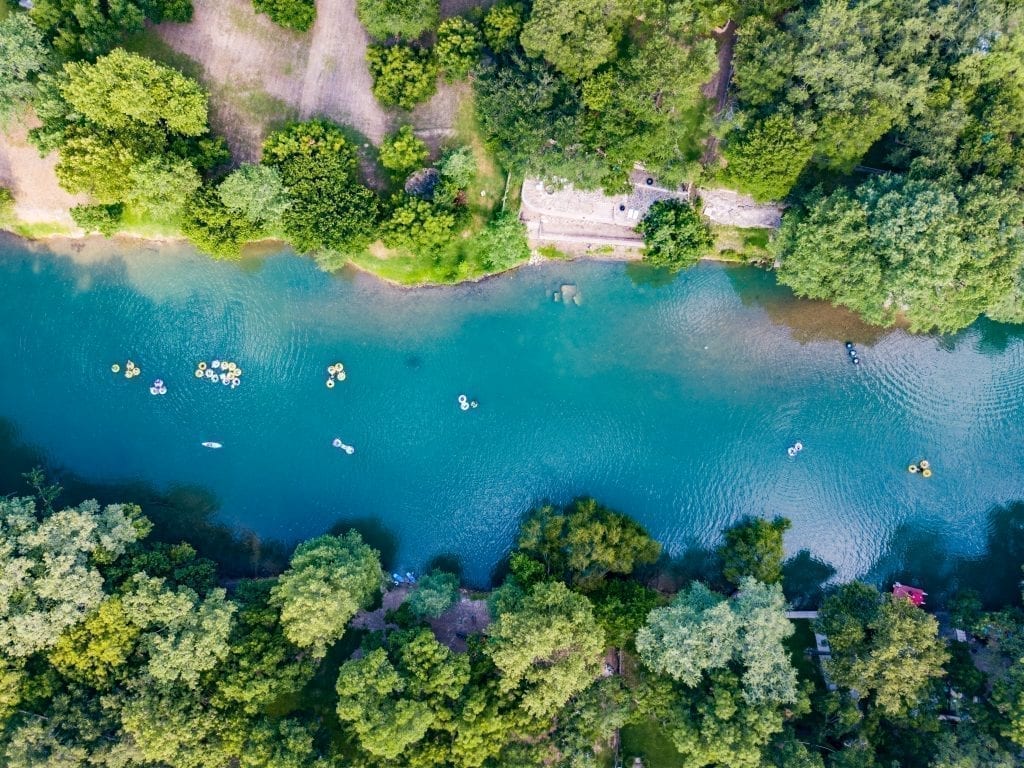 无人机从上方拍摄的德克萨斯河照片，人们漂浮在河的管子里