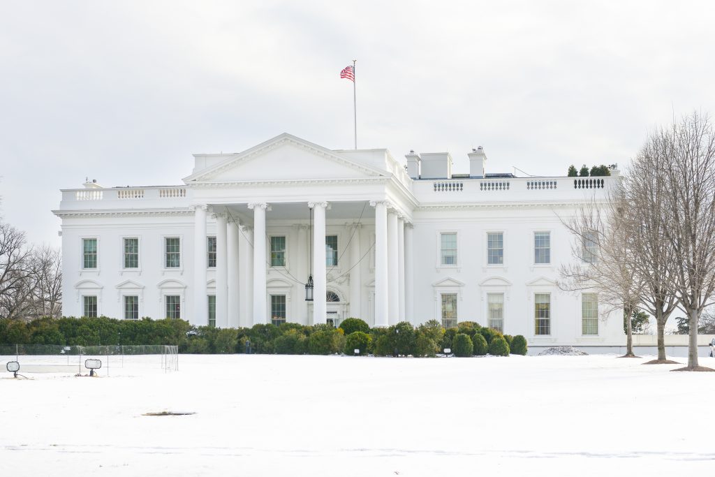 美国白宫的正立面，草坪上覆盖着雪
