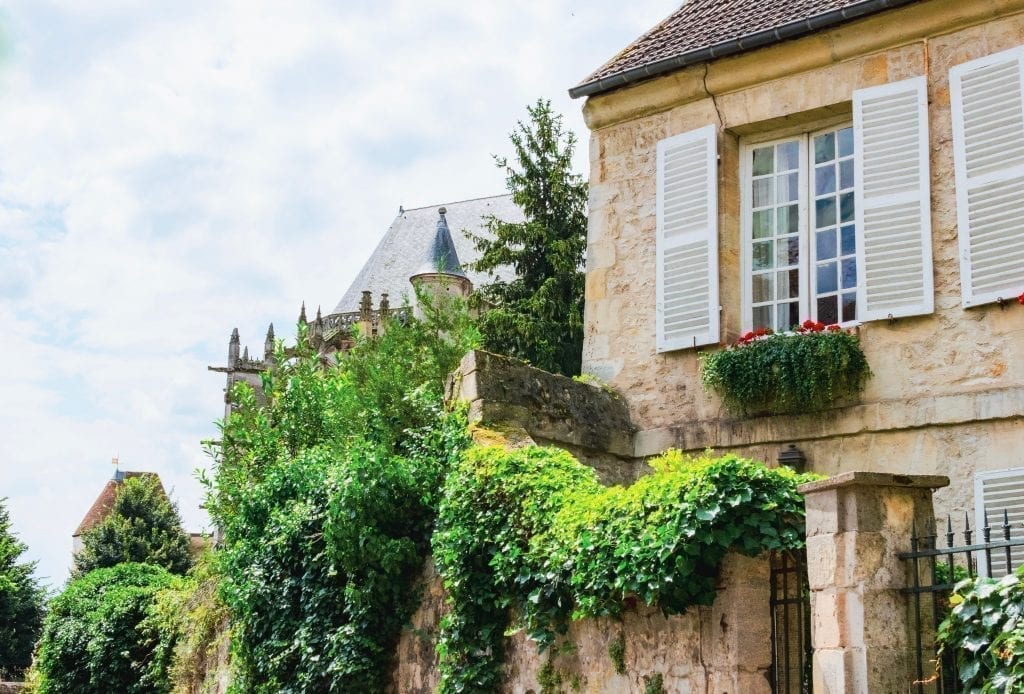 Senlis France的带有百叶窗的经典法式建筑，左侧是绿色植物