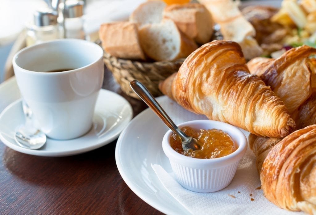 在法国，早餐用白色的盘子搭配咖啡、羊角面包、果酱和黄油