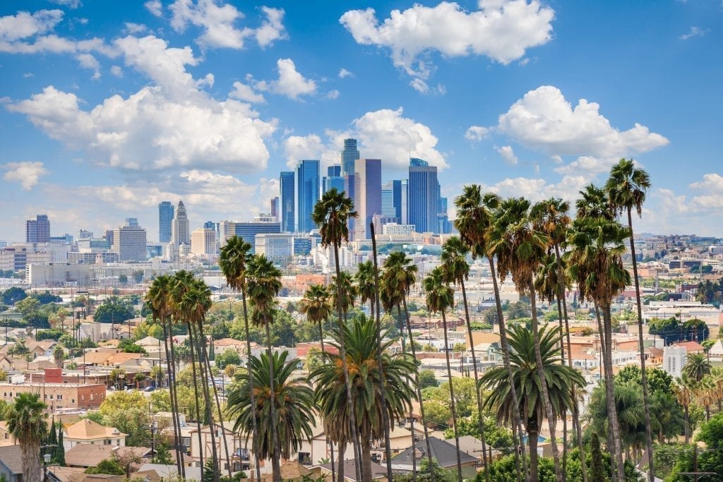 Skyline of Los Angeles CA with palm trees in the forground, one of the best places to visit in the US