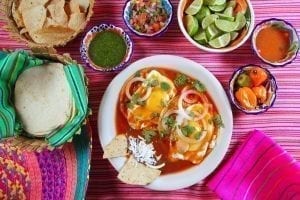 在墨西哥的一场早餐中，从上面看到的被四周包围的粉红色桌布上的墨西哥煎蛋