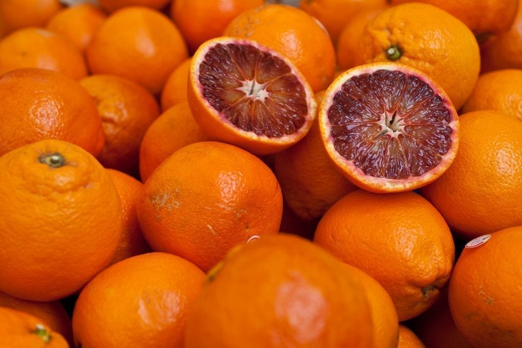 一堆血橙，上面切一半。橙子是西西里很受欢迎的食物