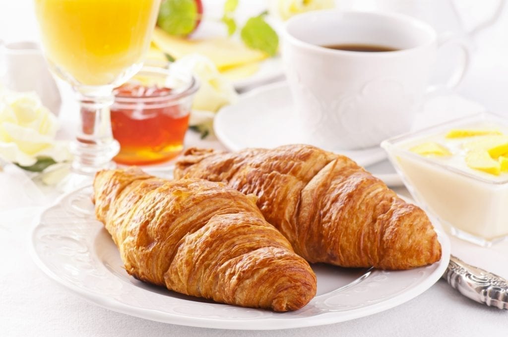 典型的法国早餐是牛角面包配咖啡和果汁，外加果酱和黄油