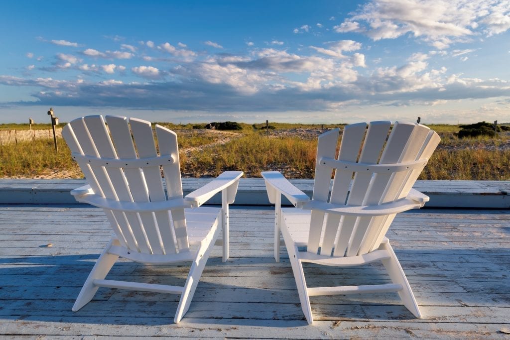 在新英格兰海岸，两张白色的椅子俯瞰着蓝天