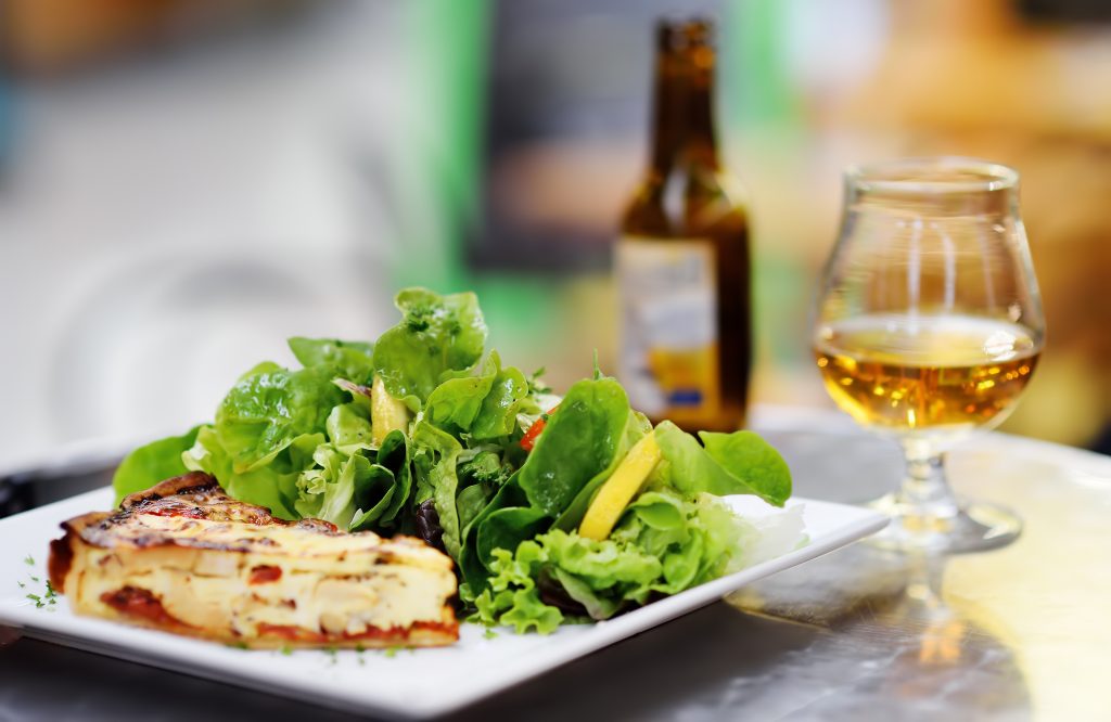 在法国的户外露台上吃午餐，有沙拉和苹果酒