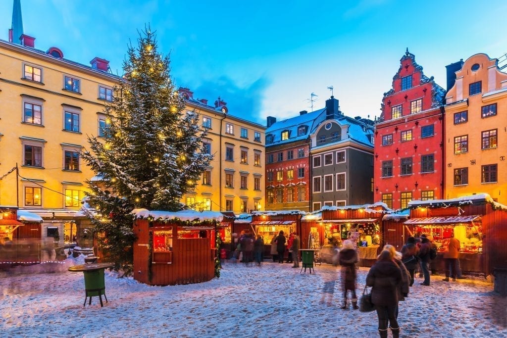 瑞典哥德堡的假日市场，中心是一棵圣诞树，背景是色彩斑斓的建筑