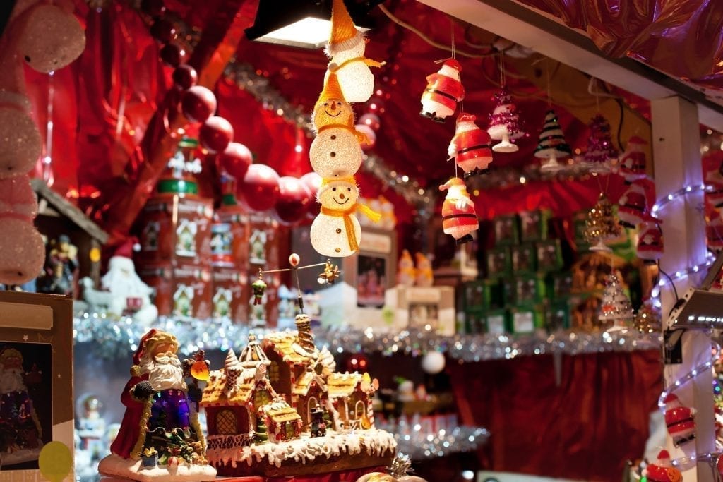 木制圣诞市场摊位出售装饰品，前景是雪人装饰品