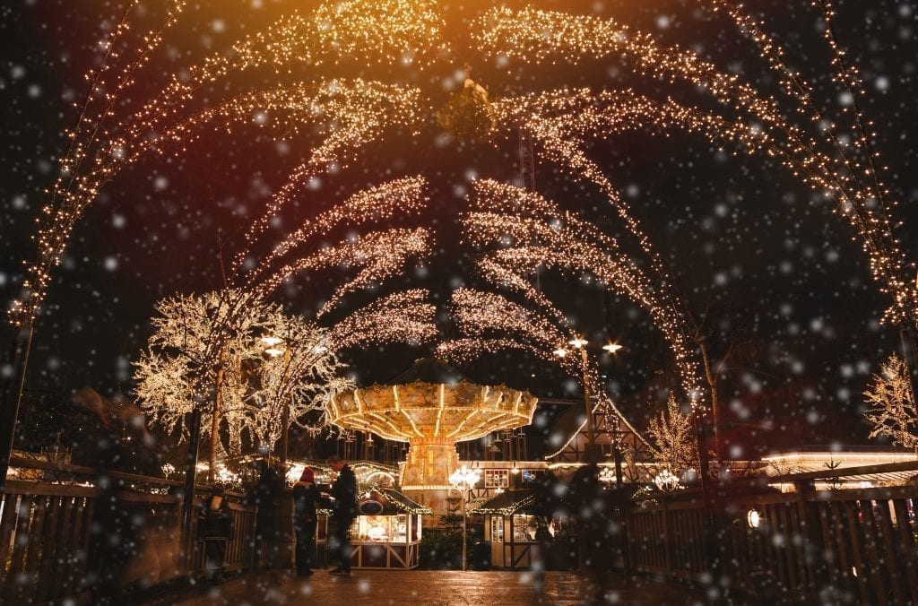 Liseberg游乐场的欧洲圣诞市场在晚上，节日的灯光装饰着旋转木马