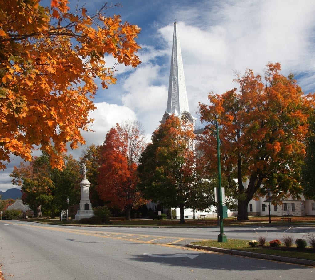 曼彻斯特佛蒙特的一条小街上的秋叶，背景中可见一座白色的教堂