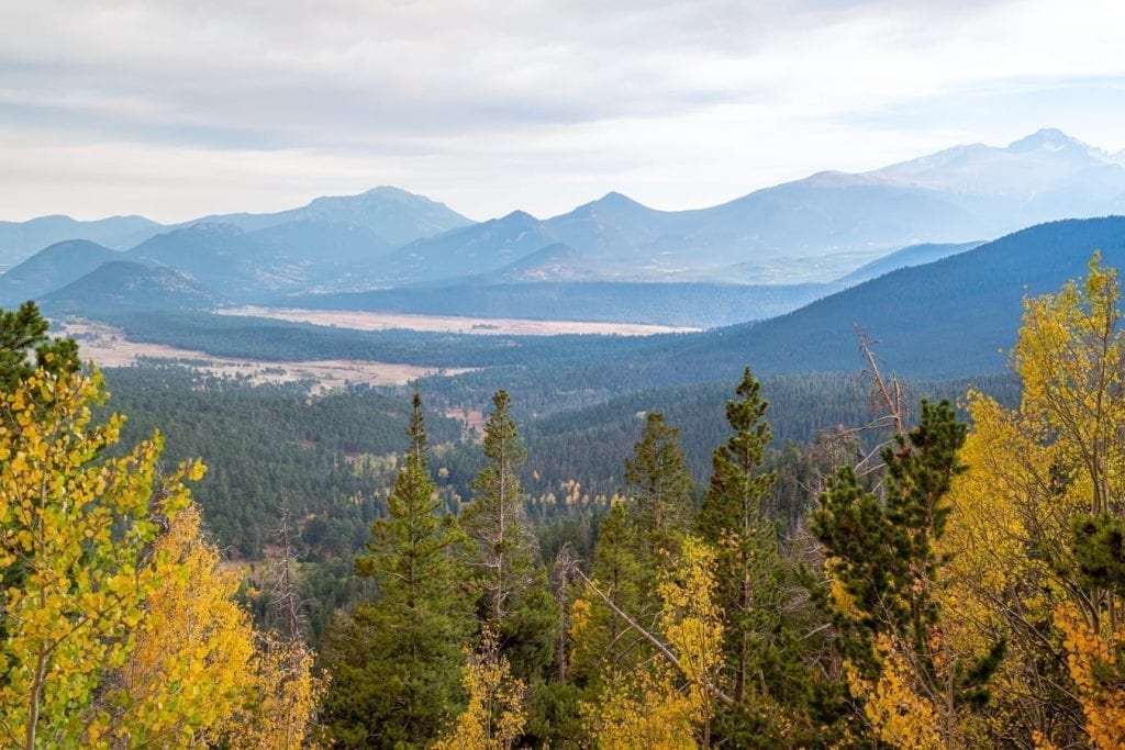 从落基山国家公园的步道山脊路看山景，前景是秋天的树叶