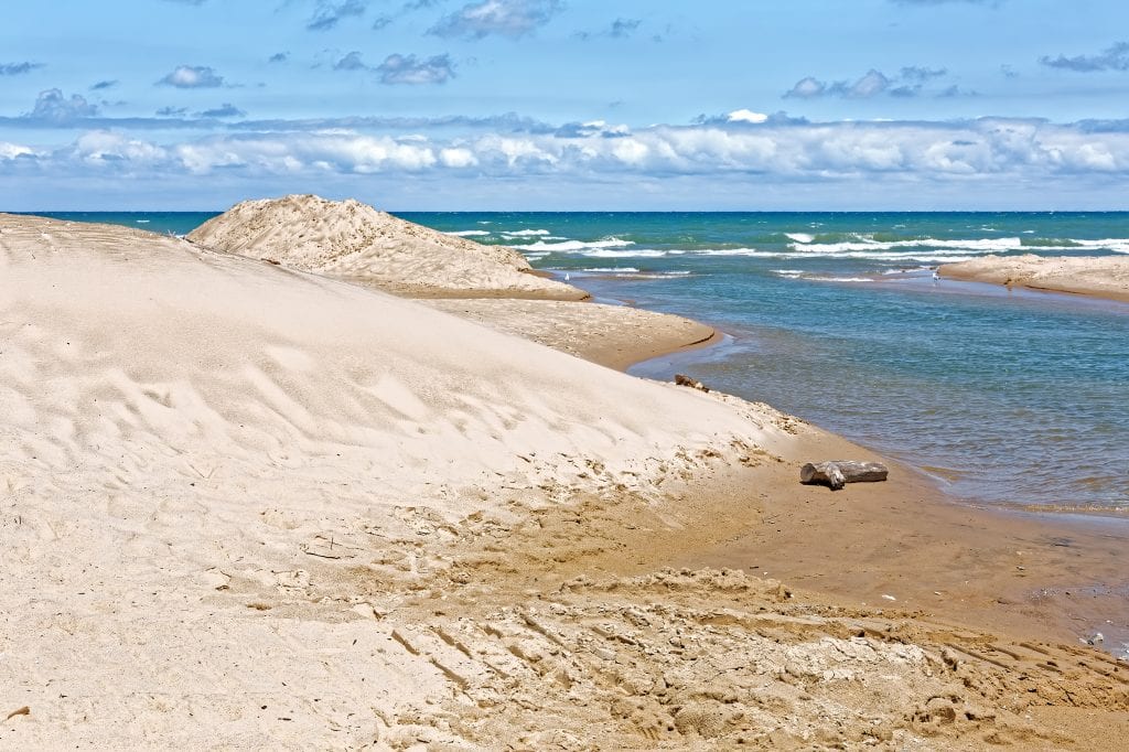 白色的沙滩在印第安纳沙丘与明亮的蓝色水在右边