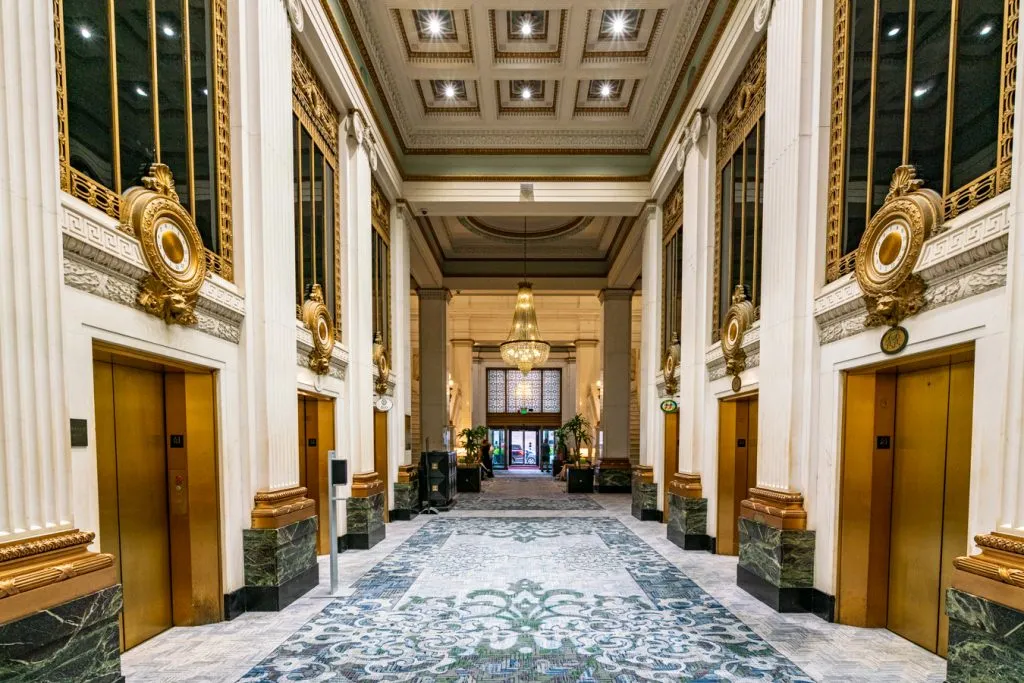 历史悠久的巴尔的摩金普顿摩纳哥酒店的黄金电梯银行，在马里兰州巴尔的摩度过长周末的最佳地点之一