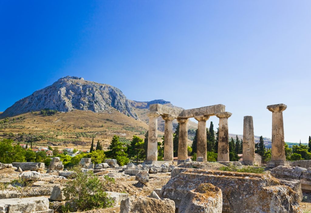 希腊科林斯的一座庙宇废墟，背景是群山