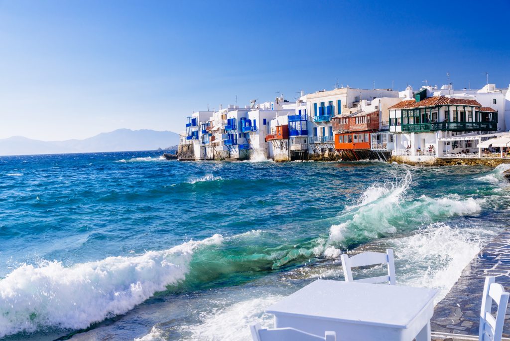 希腊米科诺斯岛的海滨景色，背景是白色的建筑，是希腊岛屿跳跃行程中最好的地方之一