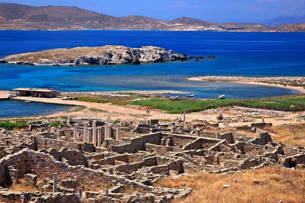 从上面俯瞰希腊的迪洛斯岛，前景是废墟，背景是大海，是希腊7日旅行的最佳站之一