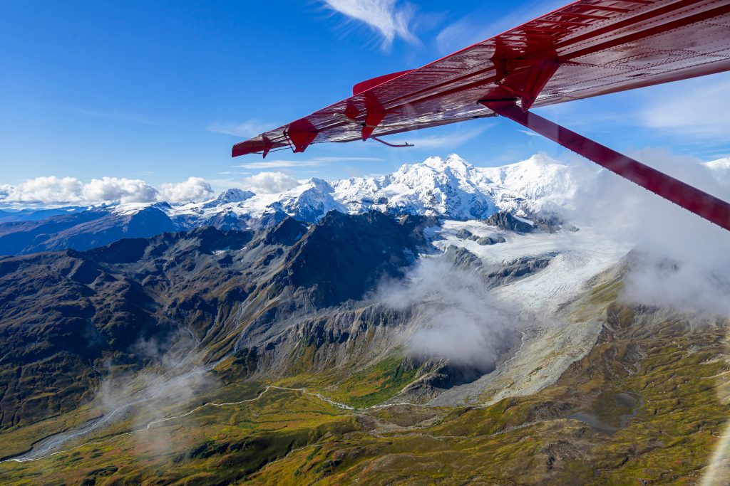 从一架红色的小飞机上俯瞰阿拉斯加的雪山，这是美国最值得做的事情之一