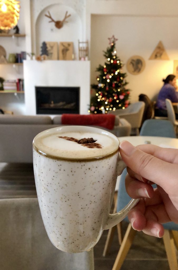 冬天的比利时，凯特在咖啡馆里端着一杯比利时热巧克力