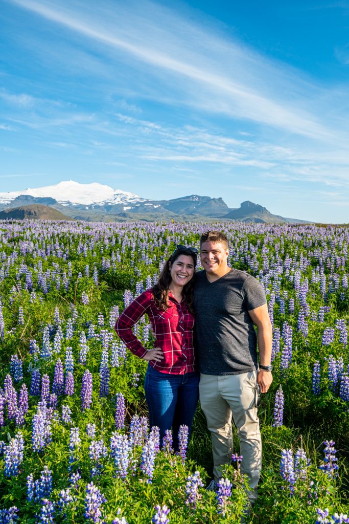 凯特·斯托姆和杰里米·斯托姆站在羽扇豆田里如何计划去冰岛的旅行