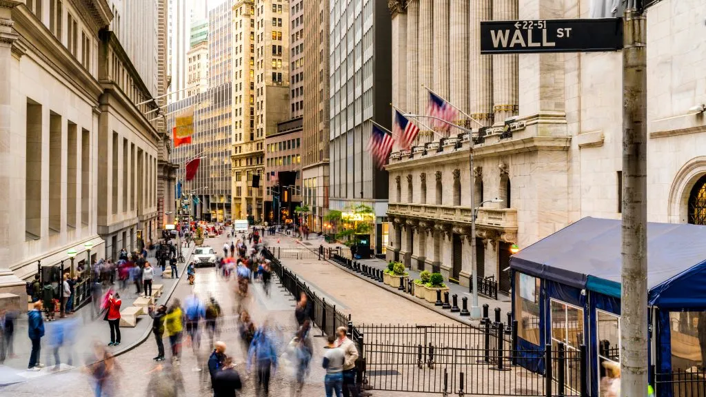 阴天，纽约华尔街的长街上，人们走过股票交易所