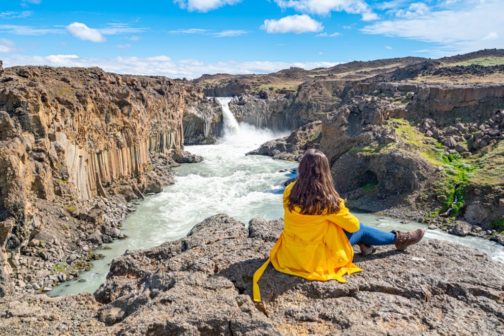 凯特·斯托姆坐在冰岛aldeyjarfoss瀑布前
