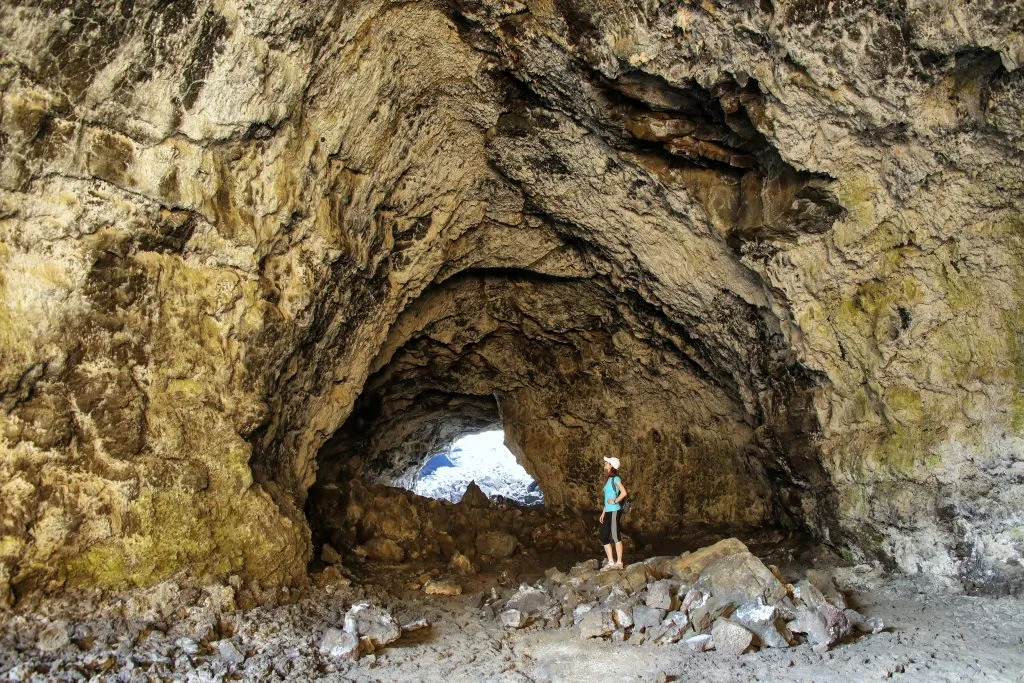 在爱达荷州月球国家纪念碑的环形山，一个徒步旅行者在它前面的印度隧道洞穴