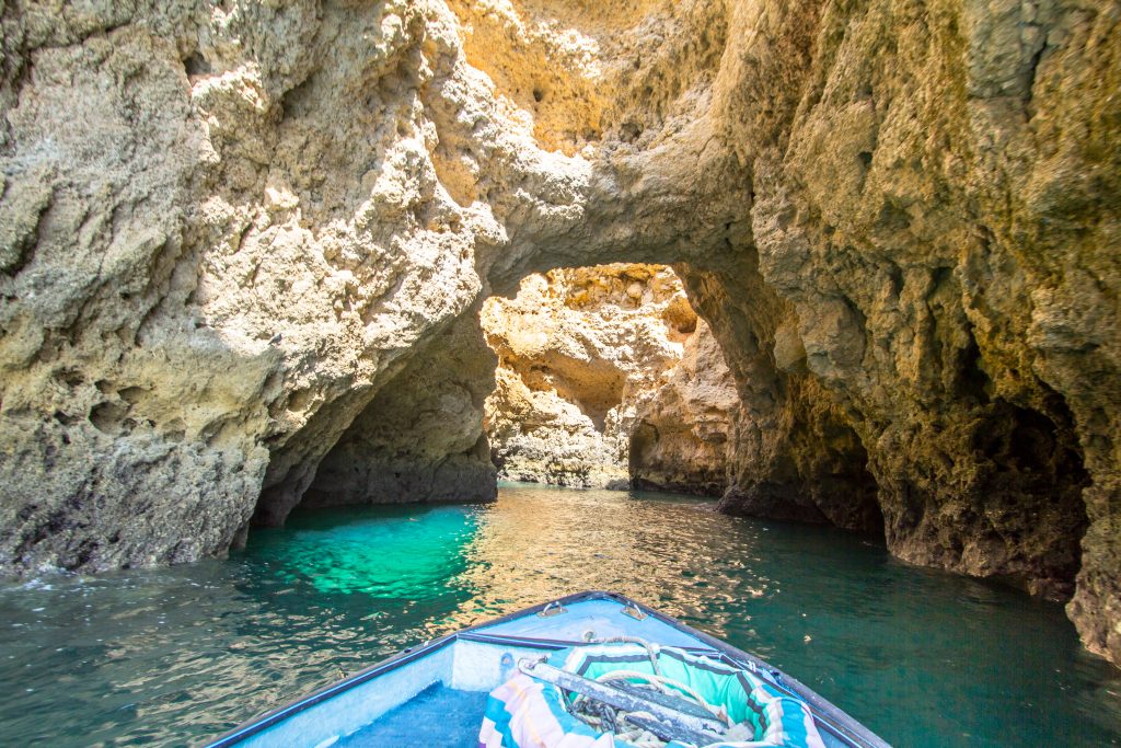 front bow of a boat entering a grotto at ponta da piedade, one of the best activities lagos portugal