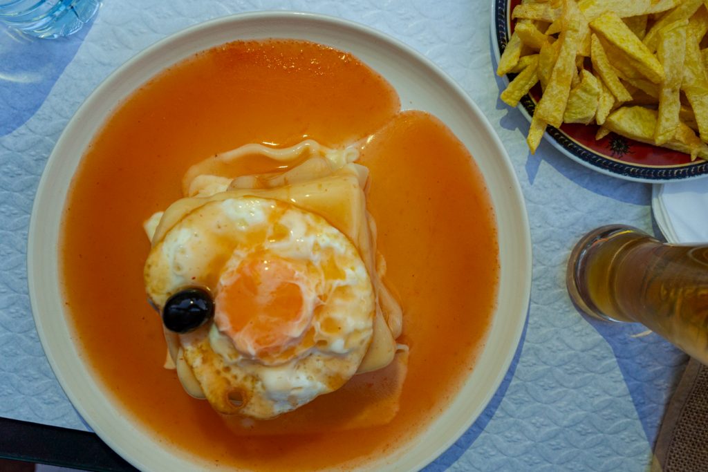 从上面看到的葡萄牙波尔图的Francesinha上面有一个鸡蛋，这是葡萄牙波尔图旅行中令人难忘的食物