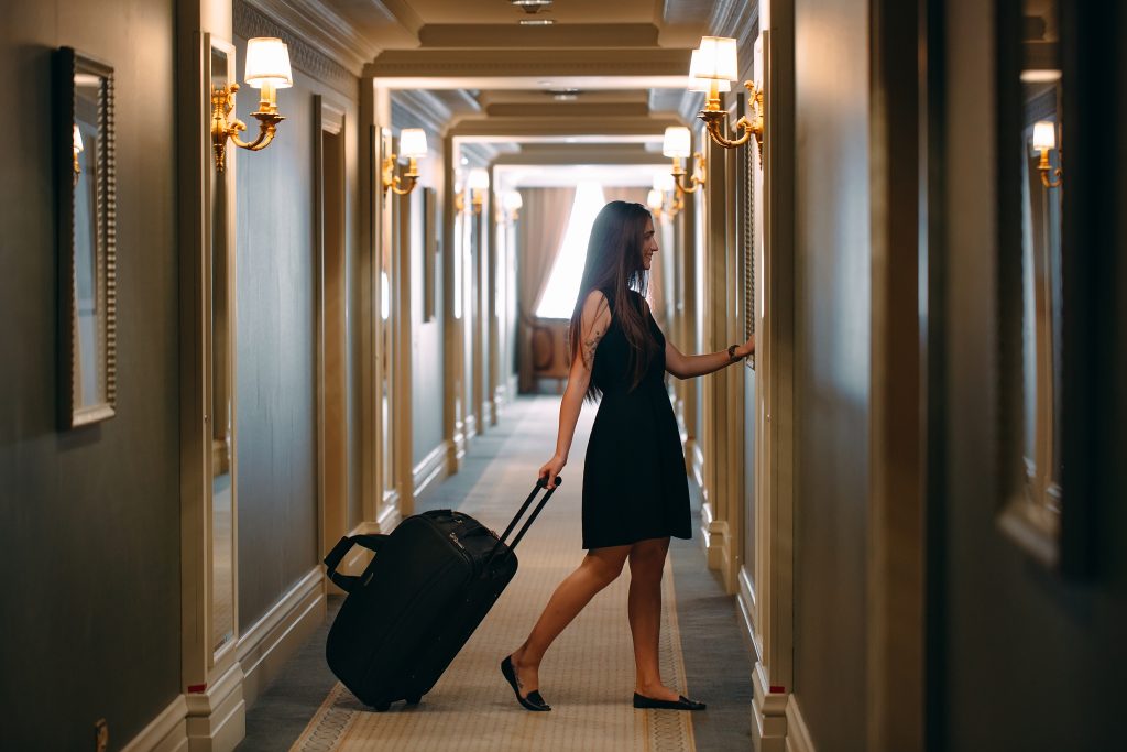 提着行李箱的女人穿过酒店走廊