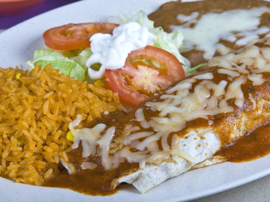 德州风味的墨西哥卷饼装在白色盘子里，配上米饭和豆子