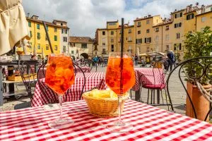 在意大利卢卡广场(piazza dell’anfiteatro)的桌子上洒上两杯aperol，这是在意大利卢卡最好的事情之一