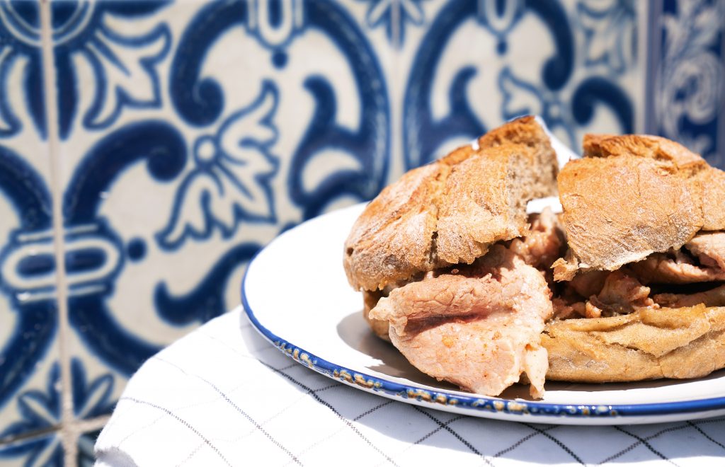在葡萄牙的azulejos餐厅前，白色盘子上的Bifana三明治