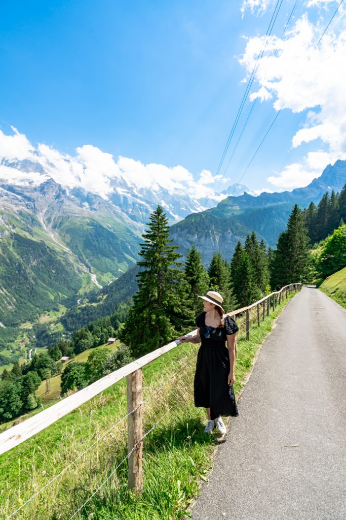 凯特身穿以阿尔卑斯山为背景的黑色连衣裙，在穆伦的奇梅尔瓦尔德徒步
