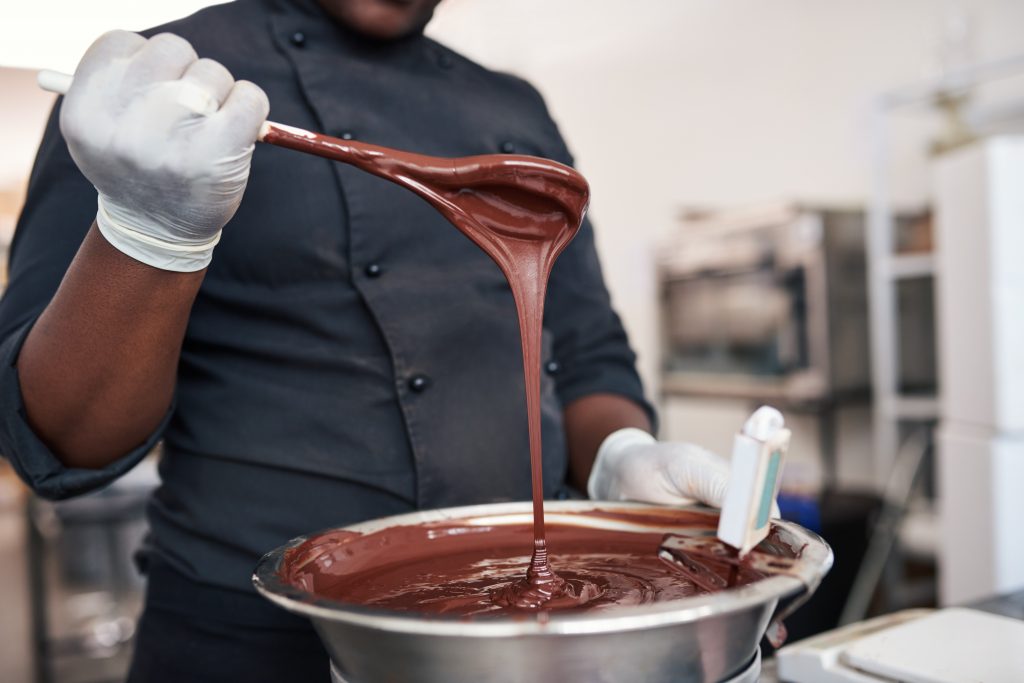男人搅拌着不锈钢碗里融化的巧克力